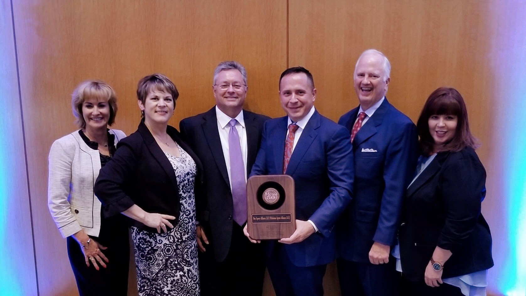 OAA leadership team holding an award