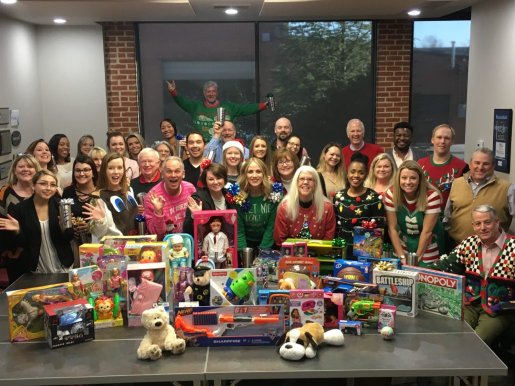 team gathered around a table of toys for Christmas drive