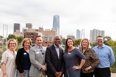 team standing in front of a big city