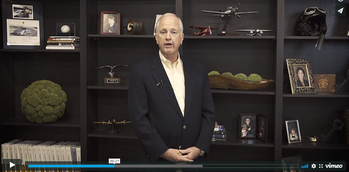 tony caldwell standing in front of bookshelves with various trinkets