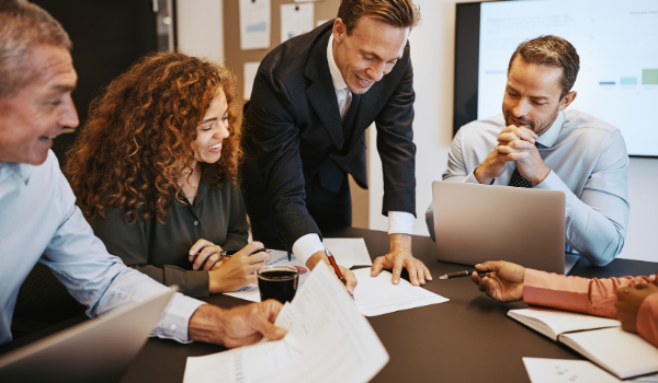 group of people around a table signing paperwork